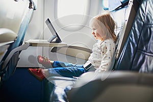 Adorable little toddler girl traveling by plane