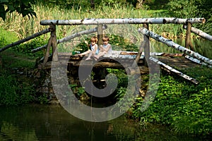 Adorable Little Twin Brothers Sitting on the Edge of Wooden Bridge and Fishing on Beautiful Lake
