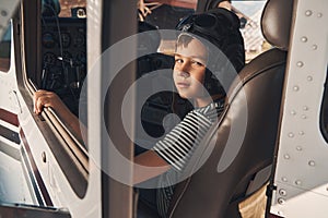 Adorable male child sitting inside airplane cockpit