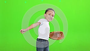 Adorable male kid with baseball mitt throwing ball ahead in studio.