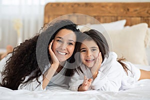 Adorable mother and daughter bonding on bed