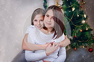 Adorable mother and daughter hugging at Christmas