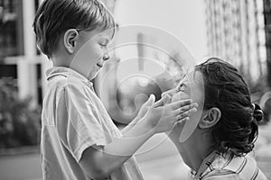 Adorable mother and son smiling happy having fun at city background. Motherhood