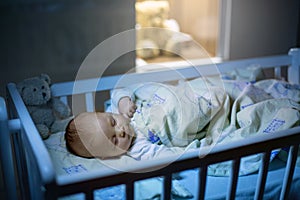 Bebé recién nacido un nino chico durmiendo en Escena de Navidad por la noche 