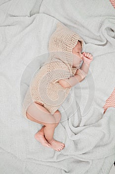 Adorable newborn baby peacefully sleeping on a white blanket.