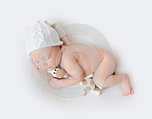 Adorable newborn baby sleeps holding a toy