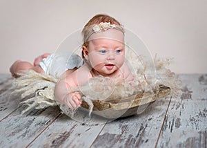 Adorable newborn girl lying on tummy on rug