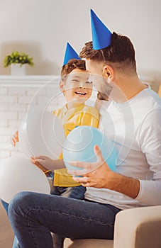 Adorable optimistic boy and man amusing with balloons