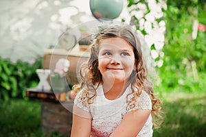 Adorable pensive schoolgirl smiling and looking away. Learning outside the auditorium during coronavirus quarantine. Back to