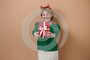 Adorable photo of attractive woman with beautiful smile holding a red gift box Christmas and New Year concept