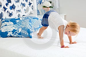 Adorable playful toddler girl in bedroom