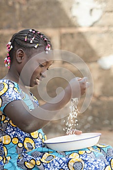 Adorable Portrait of Little African Girl Preparing Rice for Meal