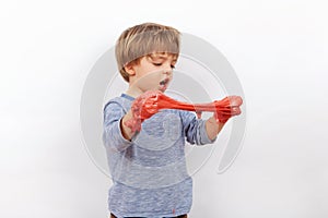 Adorable preschooler boy playing with a red slime