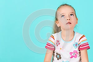 Adorable preschooler girl deep in thoughts, looking up. Concentration, decision, vision concept.