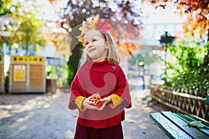 Adorable preschooler girl enjoying nice and sunny autumn day outdoors