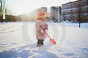 Adorable preschooler girl having fun in beautiful winter park on a snowy cold winter day