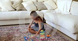 Adorable preschooler girl plays with plastic construction toy set