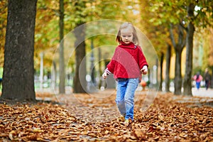 Adorable preschooler girl walking in Tuileries garden in Paris, on a fall day