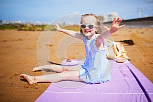 Adorable preshooler girl playing on the sand beach at Atlantic coast of Brittany, France