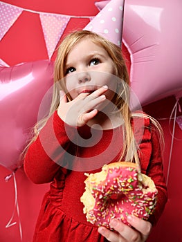 Adorable pretty girl with pink balloons and red present gift and birthday cap