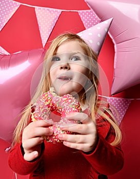 Adorable pretty girl with pink balloons and red present gift and birthday cap