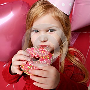 Adorable pretty girl with pink balloons and red present gift and birthday cap