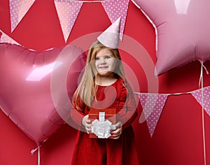 Adorable pretty girl with pink balloons and red present gift and birthday cap