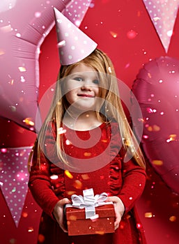 Adorable pretty girl with pink balloons and red present gift and birthday cap