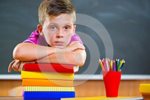 Adorable schoolboy with stack of books