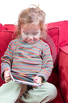 Adorable shy little girl with a tablet-pc