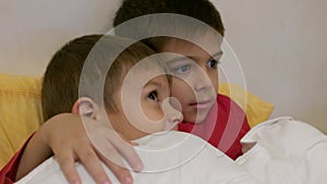 Adorable siblings hugging each other in the bed. Brothers cuddling in the bed. Happy family love and joy