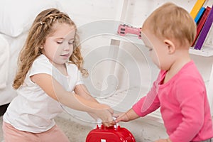 adorable sisters taking first aid kit