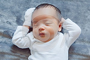 adorable sleeping Asian Chinese mixed race newborn baby girl boy lying on bed
