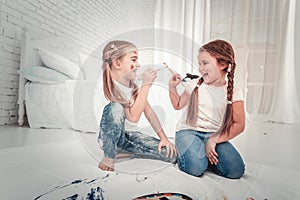 Adorable small girls drawing in white bedroom photo