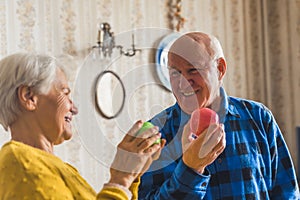 Adorable smiley senior caucasian couple in an old fashioned apartment looking at each other and smiling while holding