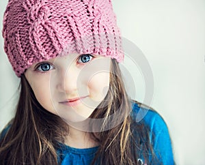 Adorable smiling child girl in pink knitted hat