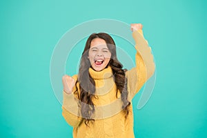Adorable smiling girl wear yellow sweater turquoise background. Positivity concept. Good vibes. Emotional baby. Positive