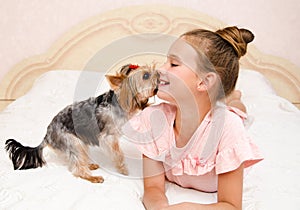 Adorable smiling happy little girl child playing with puppy yorkshire terrier