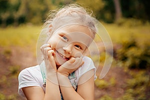 Adorable smiling little blonde girl with braided hair. Cute child having fun on a sunny summer day outdoor.