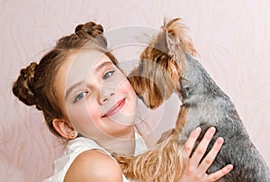 Adorable smiling little girl child schoolgirl holding and playing with pet dog