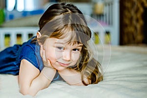 Adorable smiling little girl waked up in her bed