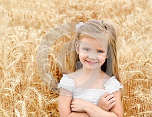 Adorable smiling little girl in the wheat field