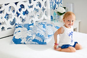 Adorable smiling toddler girl in bedroom