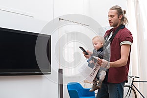 adorable son playing with remote controller father