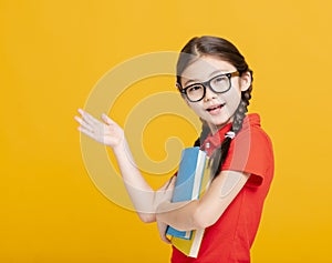 Adorable student girl  holding the books  and showing something