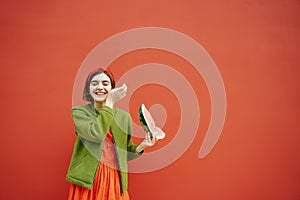 Adorable stylish young girl holding slice of watermelon and looking side profile.Long red banner. Young brunet girl eating waterme