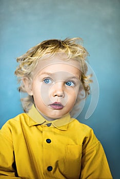 Adorable sweet little boy with golden hair and blue eyes