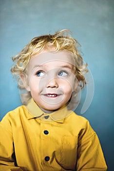 Adorable sweet little boy with golden hair and blue eyes