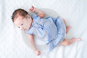 Adorable tiny newborn baby girl in a blue dress