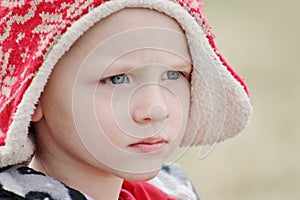 Adorable toddler boy close up in a winter hat